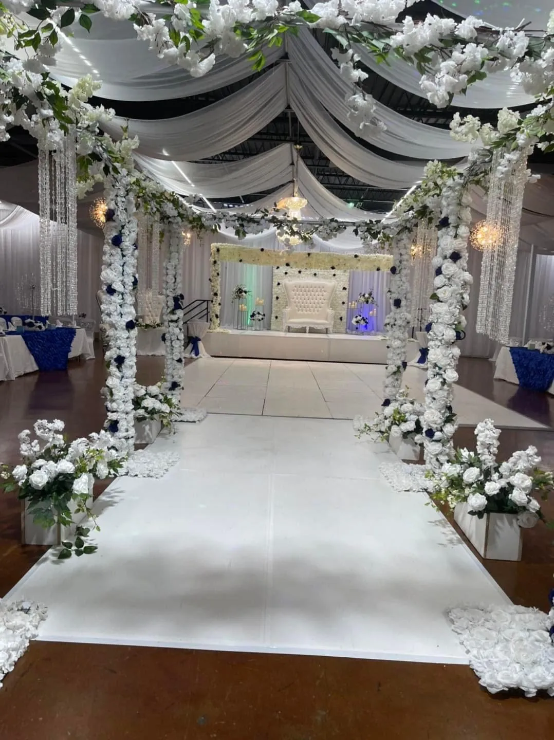 White aisle runner lined with floral arches